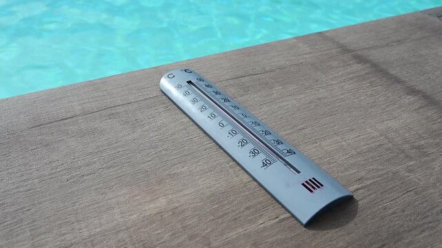 Thermometer and swimming pool in France during a heatwave and the hottest day recorded in the country.