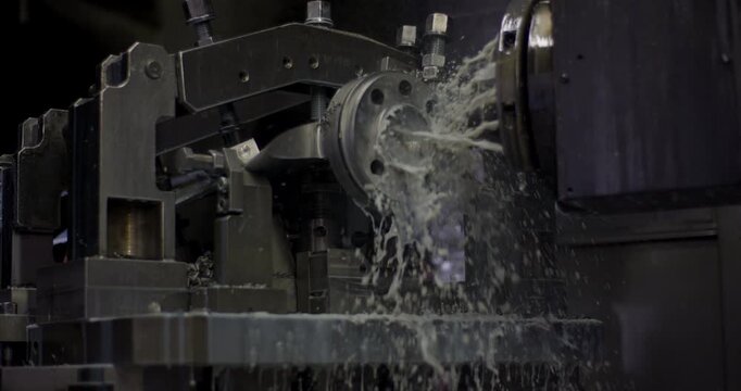 Industrial machine tool using a coolant stream while processing a circular metal component