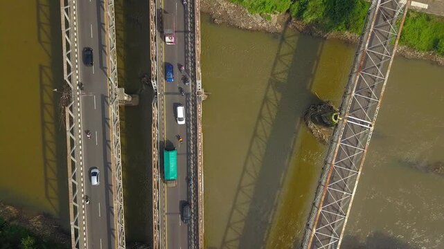 Top-Down Aerial Drone of Road Bridge Over Brown Tropical River with Traffic, Central Java, Indonesia