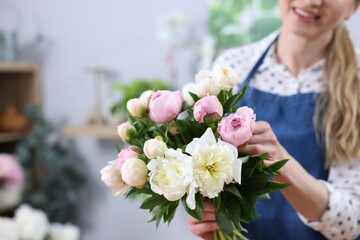 Fototapeta premium Florist making bouquet of beautiful peonies in shop, closeup. Space for text
