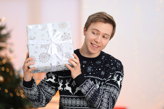 Happy man with Christmas gift at home