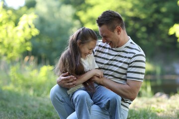 Fototapeta premium Smiling father and his daughter having fun outdoors on sunny day