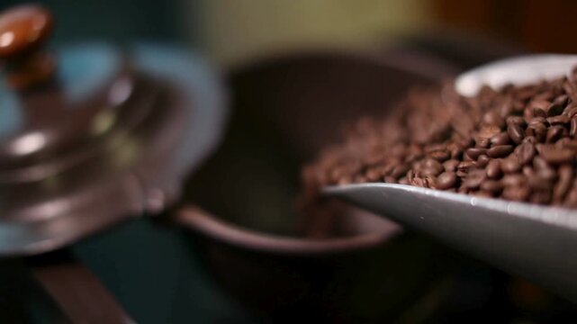 Roasted coffee beans pouring from metal scoop into vintage grinder, aromatic dark brown coffee seeds, traditional cafe brewing process