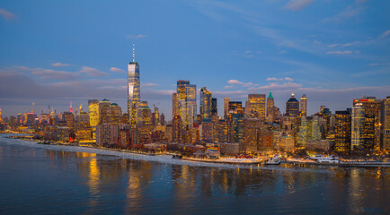 Naklejka premium NYC Manhattan skyline at night. New York City glowing panorama. New York downtown cityscape. Manhattan waterfront skyline.