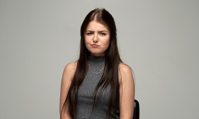 Naklejka premium Young woman showing an expression of skepticism, doubt, and grimacing at something unappealing or disappointing