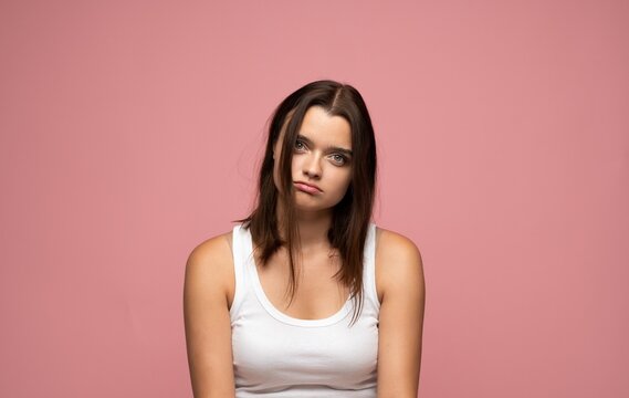 Young woman looking with a bored and tired expression, showing disinterest and apathy in a studio portrait