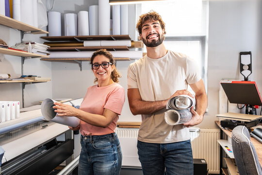 A print shop worker stands confidently in the production area, surrounded by printing equipment and materials. The portrait highlights professionalism, experience, and dedication to quality work.