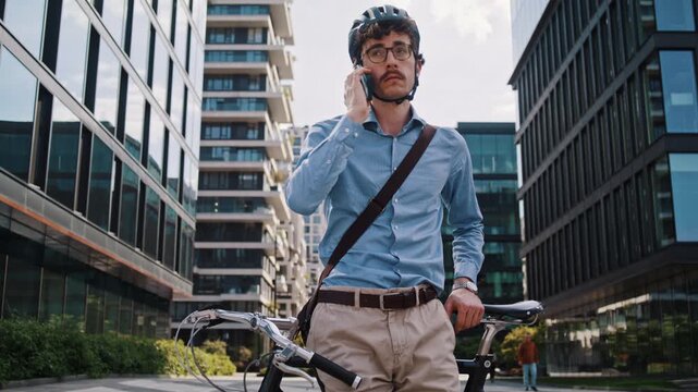 Man calls friend near bicycle on modern business office square