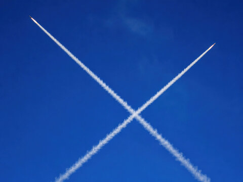 Crossing Missile Trails in Blue Sky During Air Defense Interception