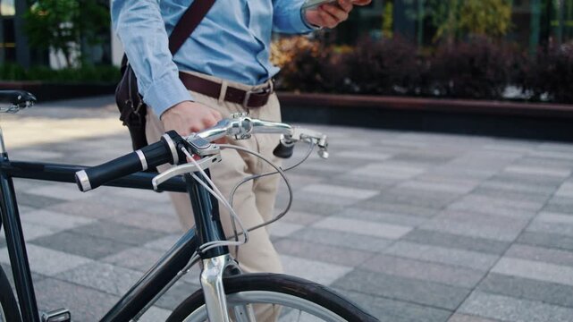 Man checks phone above bicycle handlebars during commute