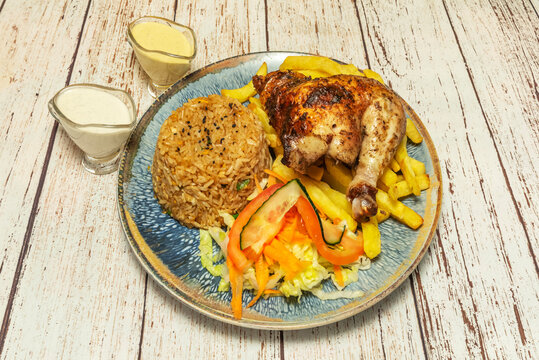 A freshly served Peruvian "mostrito" plate, featuring a juicy piece of crispy-skinned broasted chicken, accompanied by a generous portion