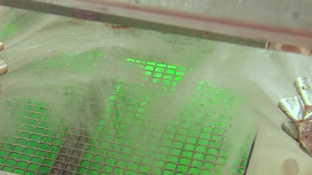 Witness elegant dance of water mist enveloping brilliant green filter, diligently scrubbing pollutants from air. This active hydro filtration demonstration occurs within pristine testing facility.