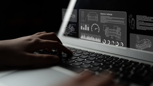 A close-up view of hands typing on a laptop displaying electric vehicle technology with graphics for motor specifications and data analysis in a digital interface. Ledger