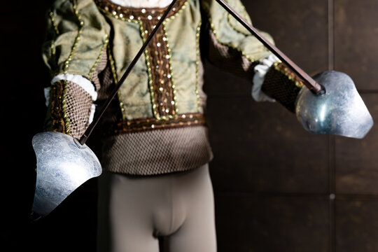 Fencer in vintage historical costume holding crossed rapiers swords from Don Quixote performance