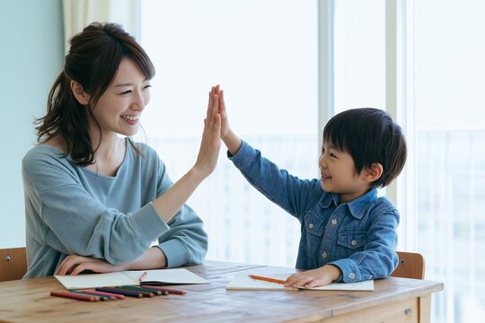 母親と男の子が笑顔でハイタッチ子育て学習風景の幸せな瞬間