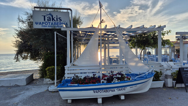 Takis Fish Restaurant features a decorative boat planter by the sea during sunset. Picture taken on June 23, 2026 in Halkidiki, Greece.
