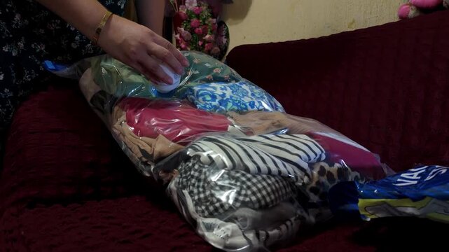 V&iacute;deo en c&aacute;mara lenta con primer plano que muestra c&oacute;mo se extrae el aire de una bolsa de almacenamiento al vac&iacute;o llena de ropa con una bomba de vac&iacute;o manual.