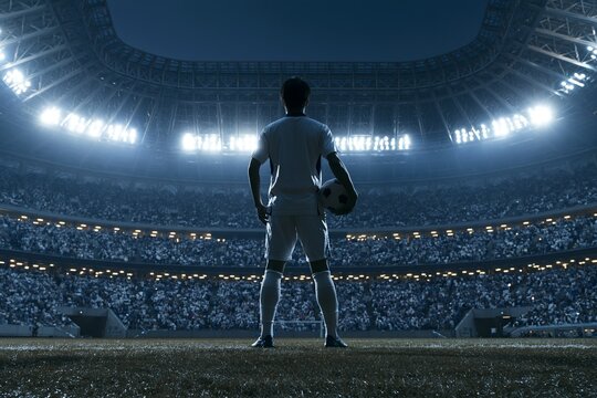 ライトアップされたスタジアムに立つサッカー男性選手