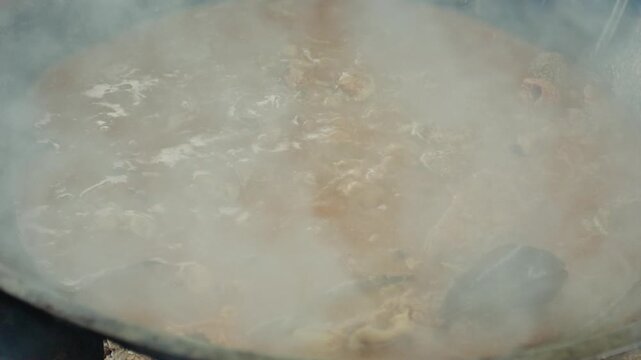 Stirring Traditional Beef Rendang with Metal Spoon in Hot Wok Creating Aromatic Steam