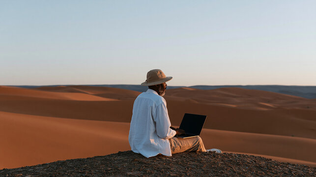 Digital nomad designer working on a laptop in a stunning desert landscape, creative remote work and travel concept, with copy space