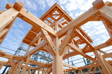 Obraz premium 青空広がる新築現場で組まれた木造建築の強固な構造