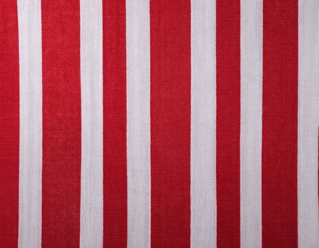 red and white striped fabric background showing a textured textile weave for various design purposes highlighting the vertical pattern and classic color combination