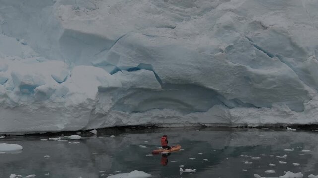 Aerial of man on paddle board near Tabular Iceberg Antarctic Peninsula 4K