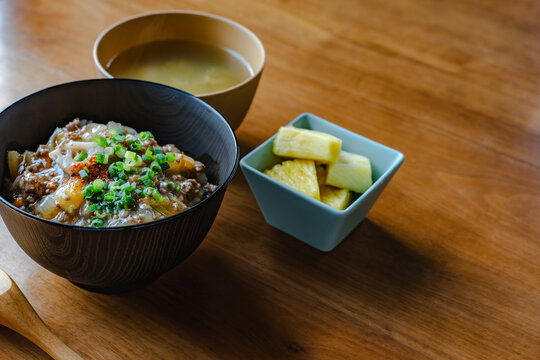 牛丼と味噌汁、カットパイナップルが並ぶ和食定食のクローズアップ写真。メニューやレシピ用