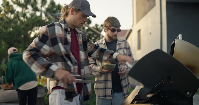 People grilling food at a backyard gathering