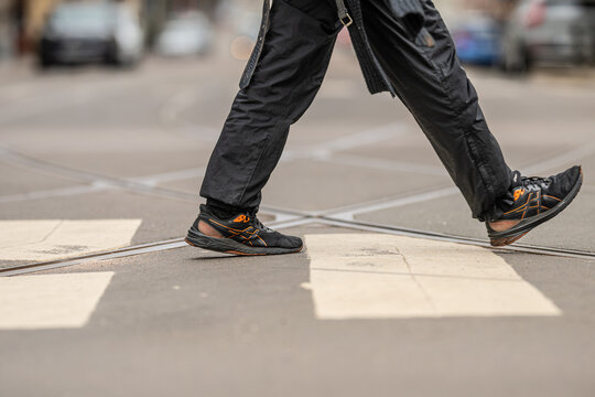 Gothenburg, Sweden - March 29 2026: Another pedestrian crossing street with dynamic stride and modern footwear focus.