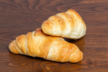 Naklejka premium Mini croissants on a wooden background. Homemade butter croissants