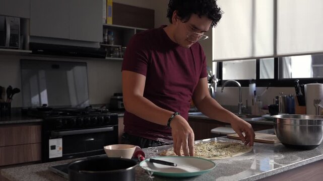 Focused man folding homemade cheese stuffed dough