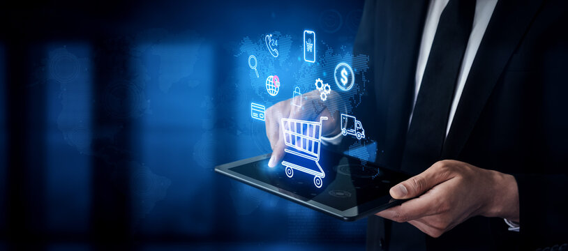 Businessman using tablet with digital shopping cart and technology icons, symbolizing online shopping and modern e-commerce solutions for retail markets. Entropy.