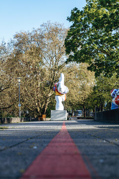 Hanover, Germany - April 21, 2026: The Red Thread tourist route leading toward the famous Nanas sculptures by Niki de Saint Phalle along the Leine River in Hanover, Germany