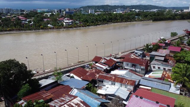 Drone aerial footage of Davao, Philippines featuring dense urban housing, residential neighborhoods, city infrastructure, bridge and compact urban development captured from above.