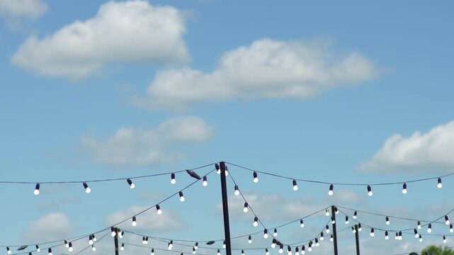 Outdoor String Lights Against Blue Sky And White Clouds