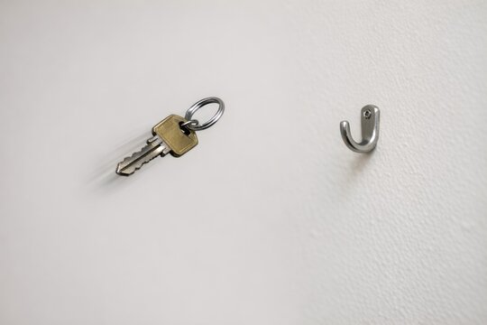 A key and a hook attached to a wall, possibly in an office or home setting