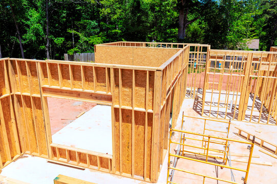 Workers are beams framing new house in residential structure is taking shape.