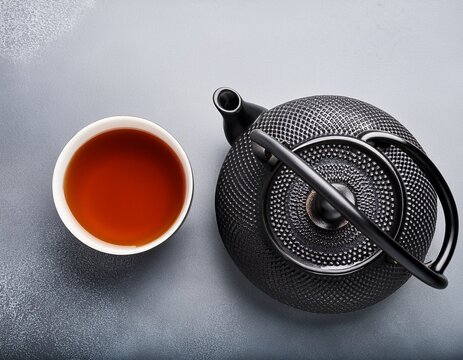 black teapot and stimming cup of tea top view