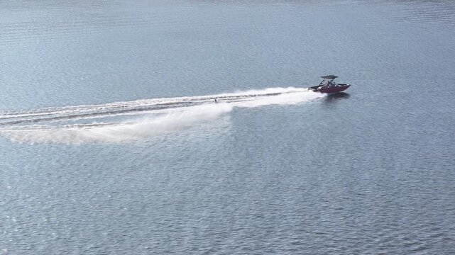 Professional Water Skier Performing Fast Slalom Turns Behind a Speedboat, Aerial View