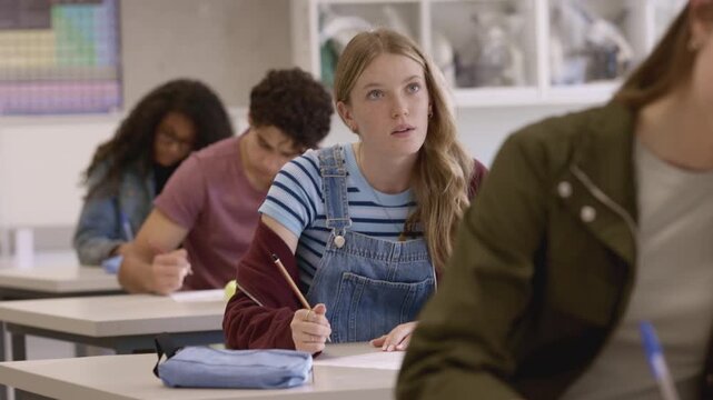 Secondary students taking test sitting in a line