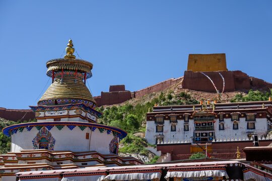 Golden Kumbum Stupa crowns Pelkor Chode Monastery's ancient fortress ruins in Gyantse, Tibet, capturing timeless Tibetan Buddhist architecture and Himalayan heritage