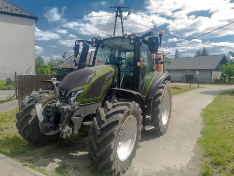 Polska Liszki (woj. małopolskie), 23 maja 2026, 14:12. Nowoczesny traktor Valtra na podjeździe do gospodarstwa. Ciągnik charakteryzuje się solidnym, czarno-zielonym nadwoziem, dużymi tylnymi kołami 