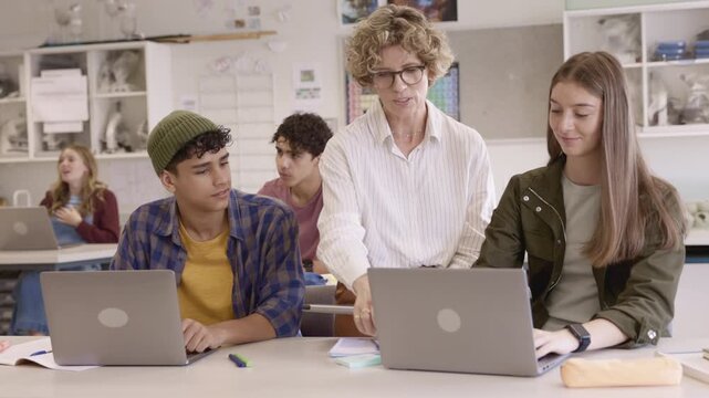 Teacher assisting student during computer class