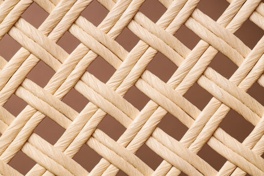 Close-up of woven natural rattan pattern with beige background