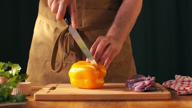 Man cut yellow sweet pepper, Chef hands with knife for onion, cutting and preparation with cooking for dish. Restaurant, culinary service and cook with skills for catering, business and hospitality by