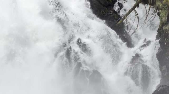 Churning water sluices over a dark rock wedge at Cascade Creek