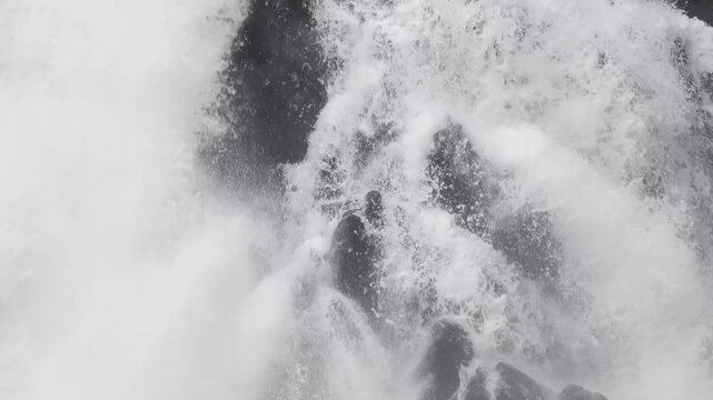 Pure spray and foam swirl around two dark pillars at Cascade Creek