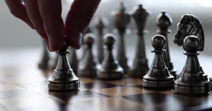 Playing chess. Man making first move with pawn, closeup