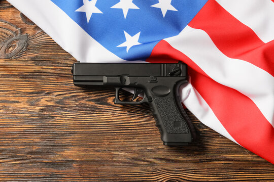 Black handgun on American flag and wooden table